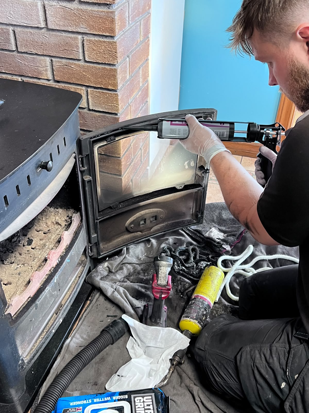 Stove door being serviced with a new fire rope seal